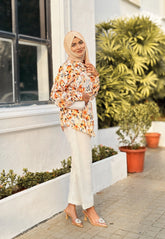 Model wearing a yellow print top and white pants with a stylish headscarf and heels
